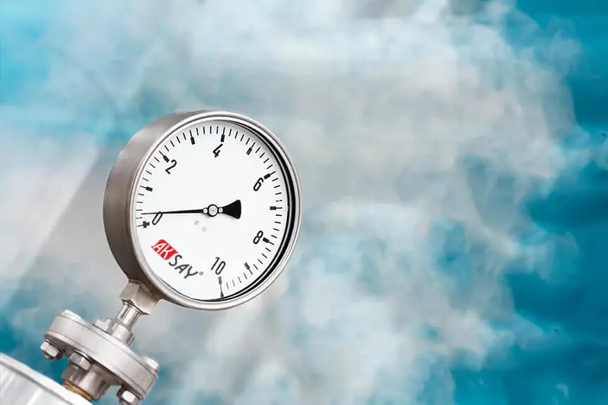 Aksay marka paslanmaz çelik analog manometre yakın çekim — beyaz kadran 0-10 skala, hava testi sırasında basınç okuması için kullanılıyor, arka planda buhar görüntüsü