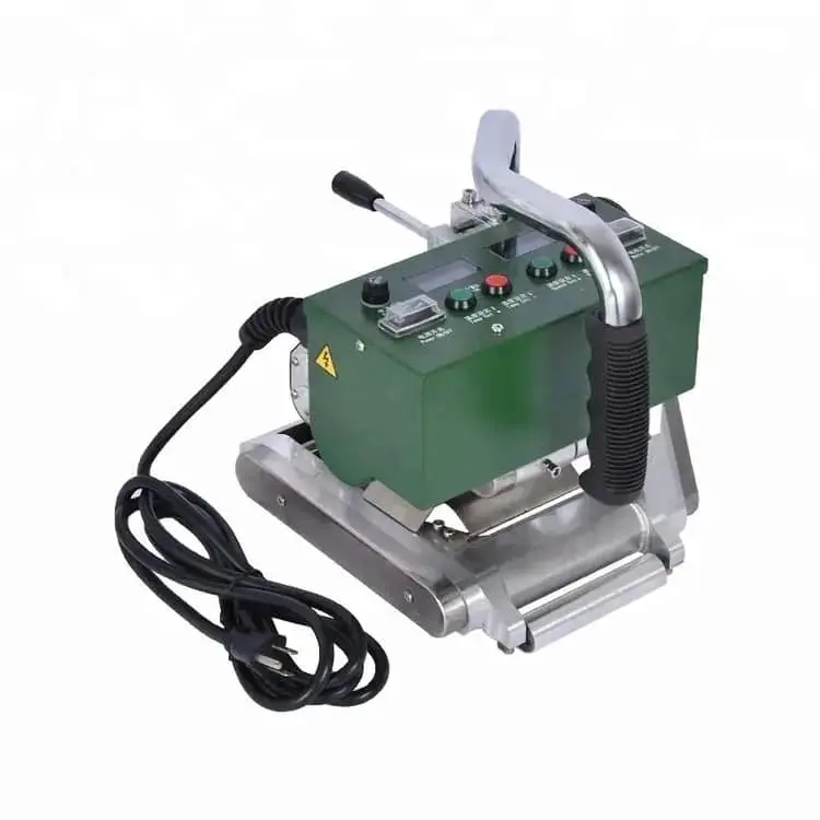 Kompakt yeşil renkli geomembran füzyon kaynak makinesi (hot wedge welder): üst kısımda LCD ekran ve kontrol düğmeleri, alt kısımda paslanmaz çelik tekerlekli platform, siyah güç kablosu, sağ tutamakta dişli mekanizması