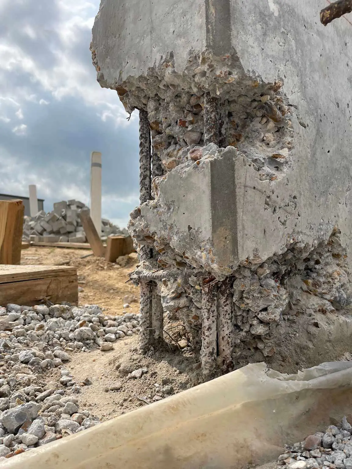 Betonarme kolonda yüksekten serbest düşüm ve yetersiz vibrasyon sonucu oluşan ağır beton hasarı — donatılar açıkta kalmış, beton bütünlüğü bozulmuş