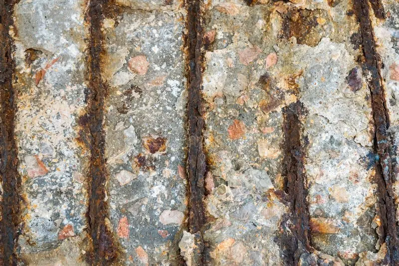 Yetersiz beton örtüsü nedeniyle korozyona uğramış betonarme yüzey: korozyonlu donatı çubukları yüzeyde açığa çıkmış, beton pas genleşmesiyle yerinden ayrılmış