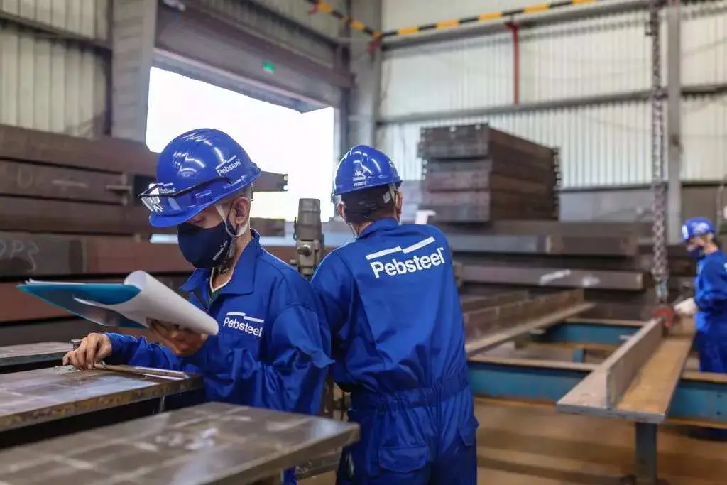 Çelik imalat fabrikasında Pebsteel işçileri çelik plakaları denetliyor