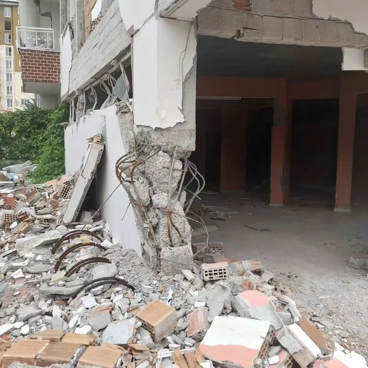 Deprem sonrası zemin kat kolon hasarı — yetersiz sarılma bölgesine sahip kolonlarda beton dökülmesi, donatı burkulması ve çökme görüntüsü