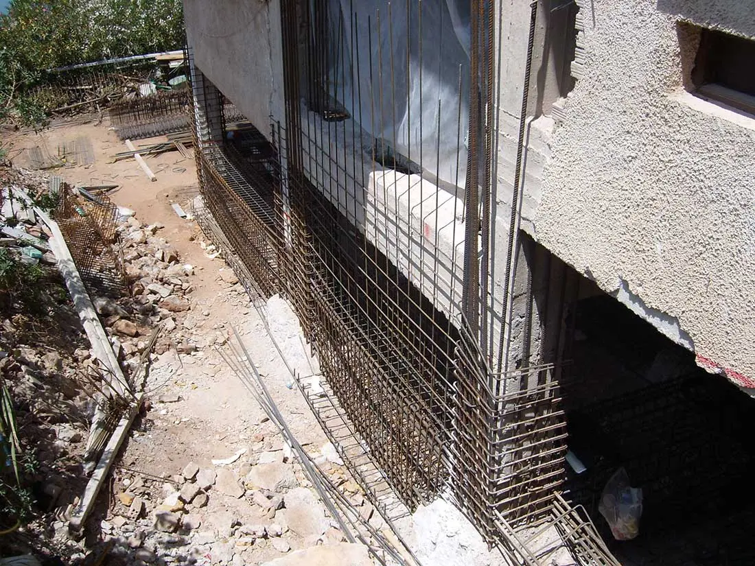 İnşaat aşamasında betonarme perde donatı kafesi: yoğun etriye düzeni ve düşey donatı çubukları