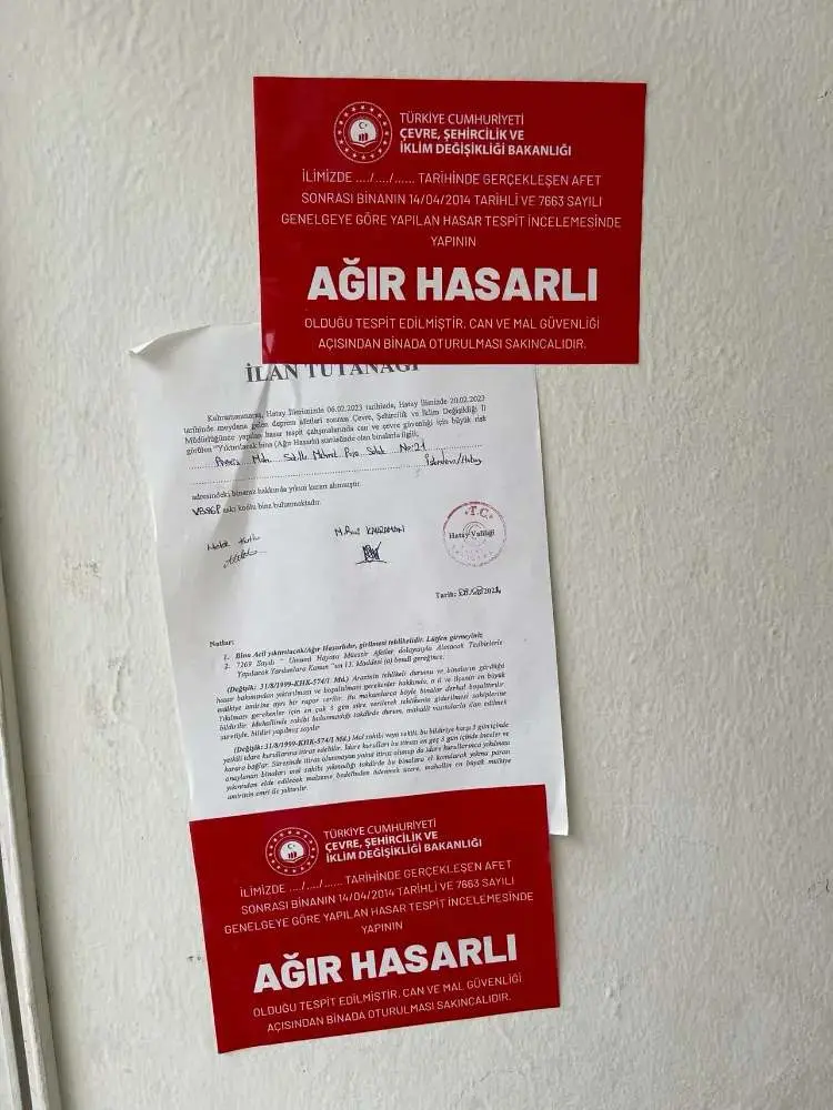 Deprem sonrası binaya yapıştırılmış kırmızı 'Ağır Hasarlı' renk kartı: AFAD hasar tespit kararı ve ilan tutanağı