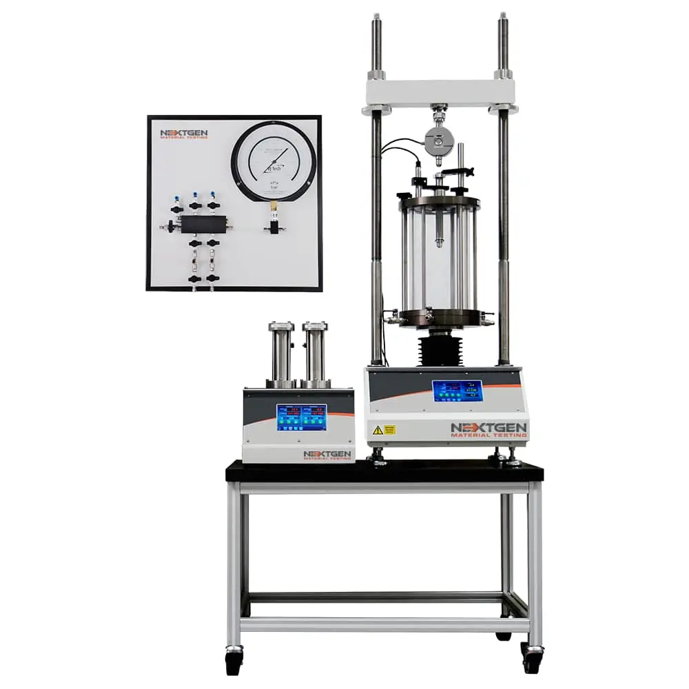 NextGen Material Testing marka triaksiyel test sistemi: yük çerçevesi, şeffaf silindirik triaksiyel hücre, basınç manometresi, valf paneli ve dijital kontrol ekranlı basınç üniteleri içeren profesyonel zemin mekaniği laboratuvar düzeneği