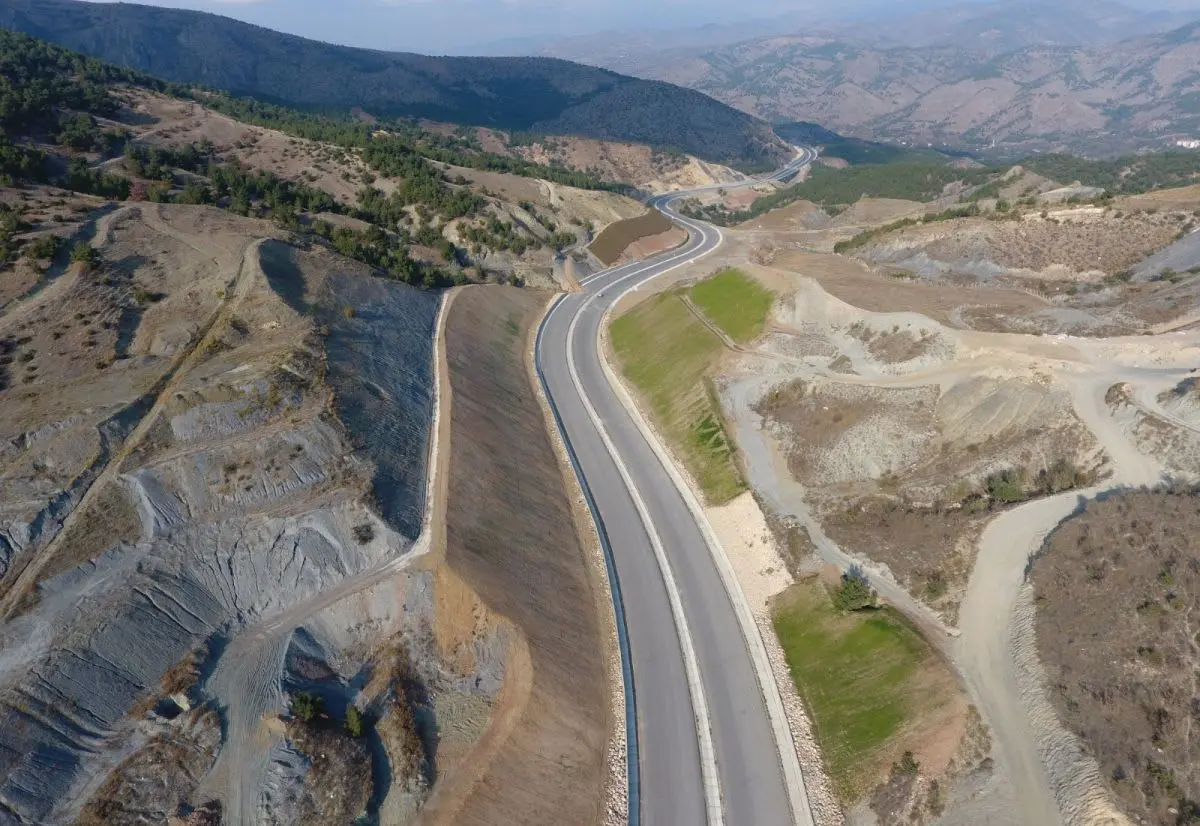 Havadan çekilmiş Türkiye otoyolu yol yarması şev stabilizasyonu; kademeli palyeli şevler ve yeşil bitki örtüsü kaplamasi, dağlık arazi üzerinde iki yönlü yol güzergâhı