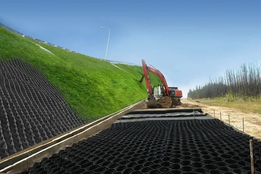 Geocell ve geogrid ile şev koruma: siyah plastik geocell panelleri şev yüzeyine serilmekte, ekskavator ile dolgu yapılıyor; tamamlanan bölümde yeşil çim örtüsü görülüyor
