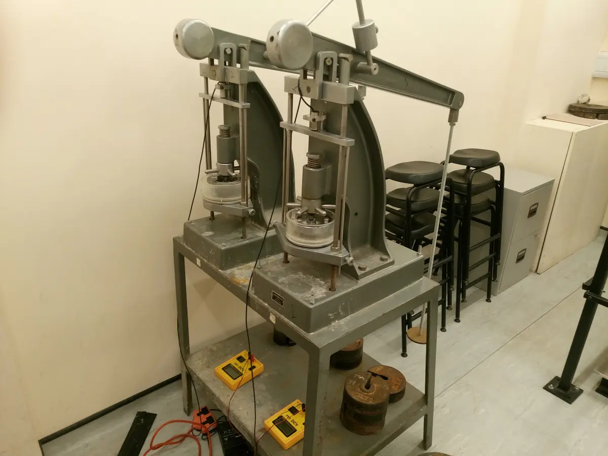 Geoteknik laboratuvar triaksiyel/konsolidasyon deney cihazları: çift hücre düzeneği, yükleme kolları ve elektronik ölçüm cihazları; numune kalitesinin deney sonuçlarına etkisi.
