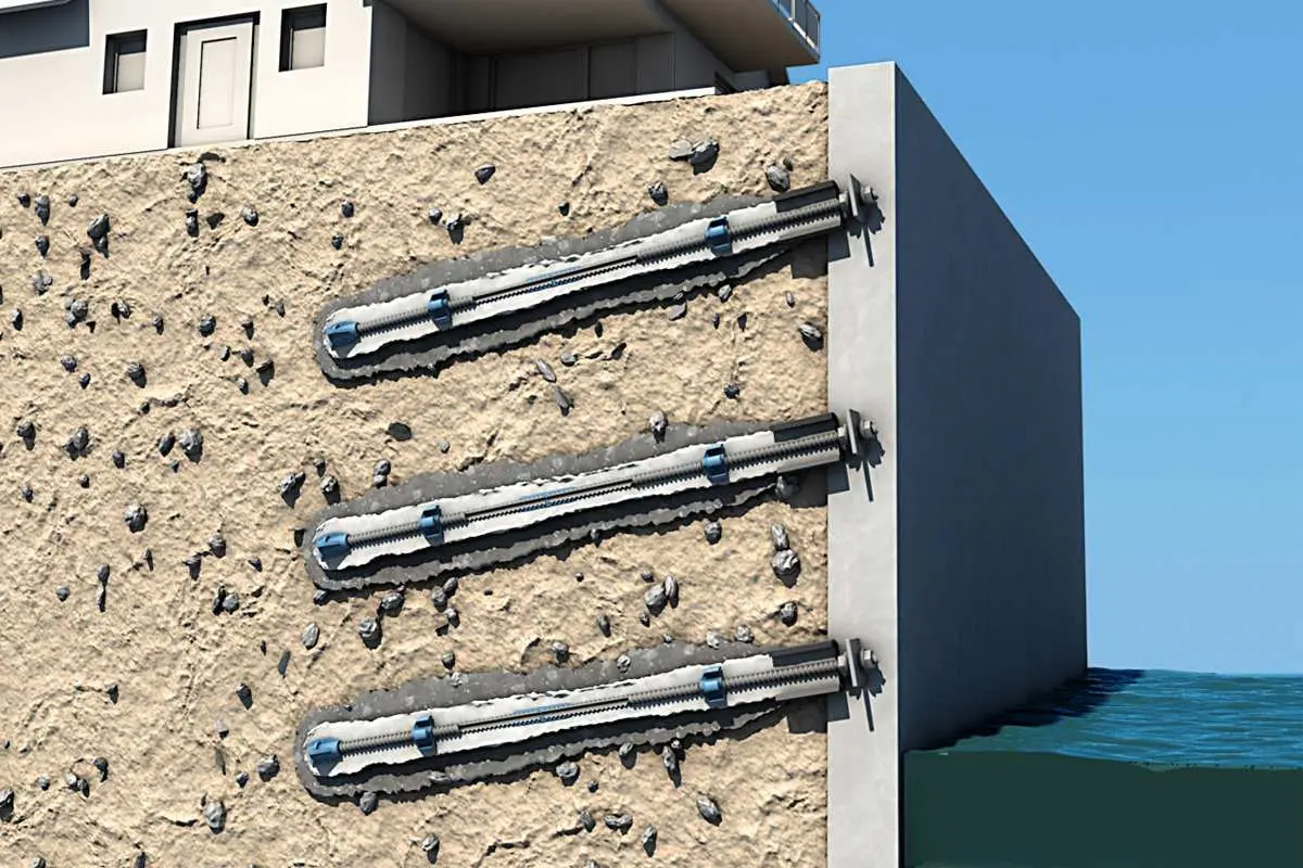 Beton duvar yüzeyine monte edilmiş üç sıra çelik ankraj başı ve taşıma plakaları — kıyı yapısı güçlendirme uygulaması