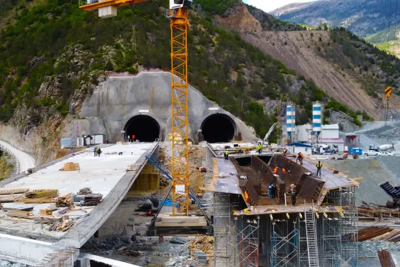 Çift tüp tünel portal inşaatı — dağ eteklerinde iki tünel ağzı, beton portal yapısı ve inşaat şantiyesi