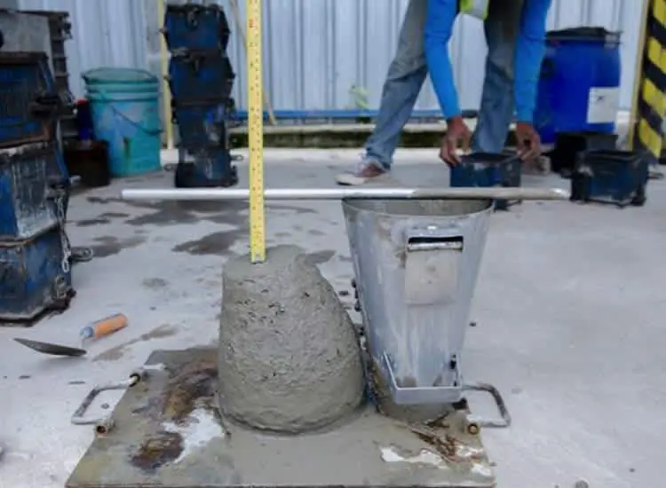 Şantiyede metal Abrams slump konisi ile çekilmiş taze beton ve cetvel ölçümü — beton kıvam tayini saha deneyi