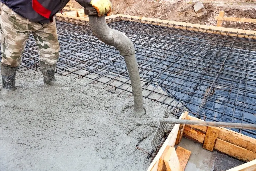 İşçi hortumla SCC dökümü — çift katlı donatılı döşeme yüzeyine kendiliğinden yerleşen beton akışı