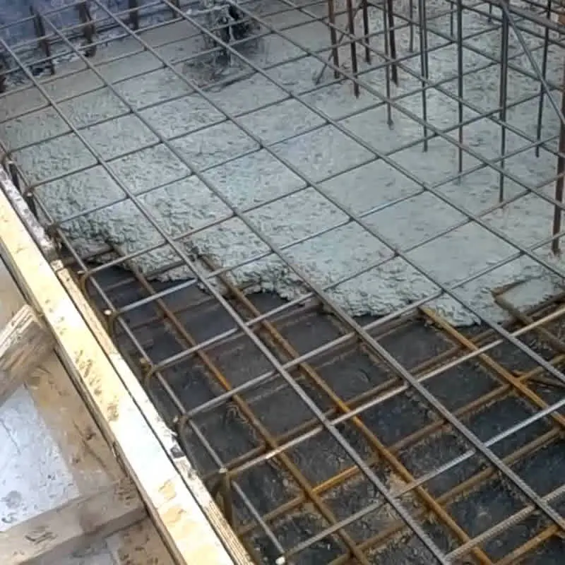 Betonarme radye temel dökümü — çift katlı donatı ızgarası üzerine KYB beton dökülüyor