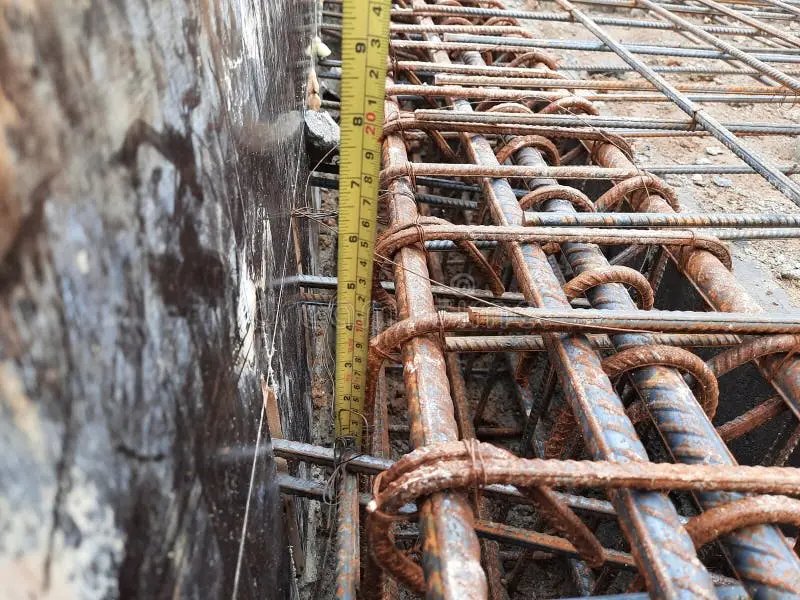 Şantiyede nervürlü betonarme çelik donatı kafesinin yanında sarı şerit metre ile metraj tespiti yapılıyor — YİGŞ Madde 39 kapsamında iş miktarı ölçümü