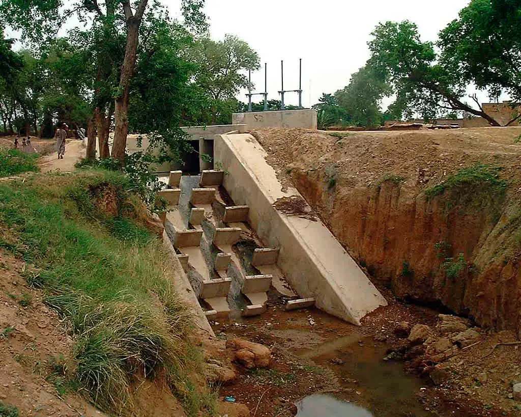 Kademeli enerji kırıcı basamak (stepped chute) saha fotoğrafı — betornarme savak basamakları, deşarj kanalı ve mansap alanı