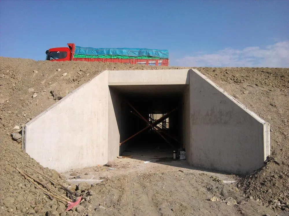 İnşaat halinde betonarme kutu menfez (culvert) giriş yapısı saha fotoğrafı — kanat duvarları ve üstten geçen kamyon