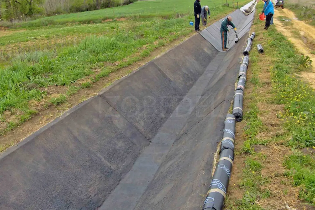 Trapez toprak kanal üzerine HDPE jeomembran geomembrane serim ekibi saha fotoğrafı