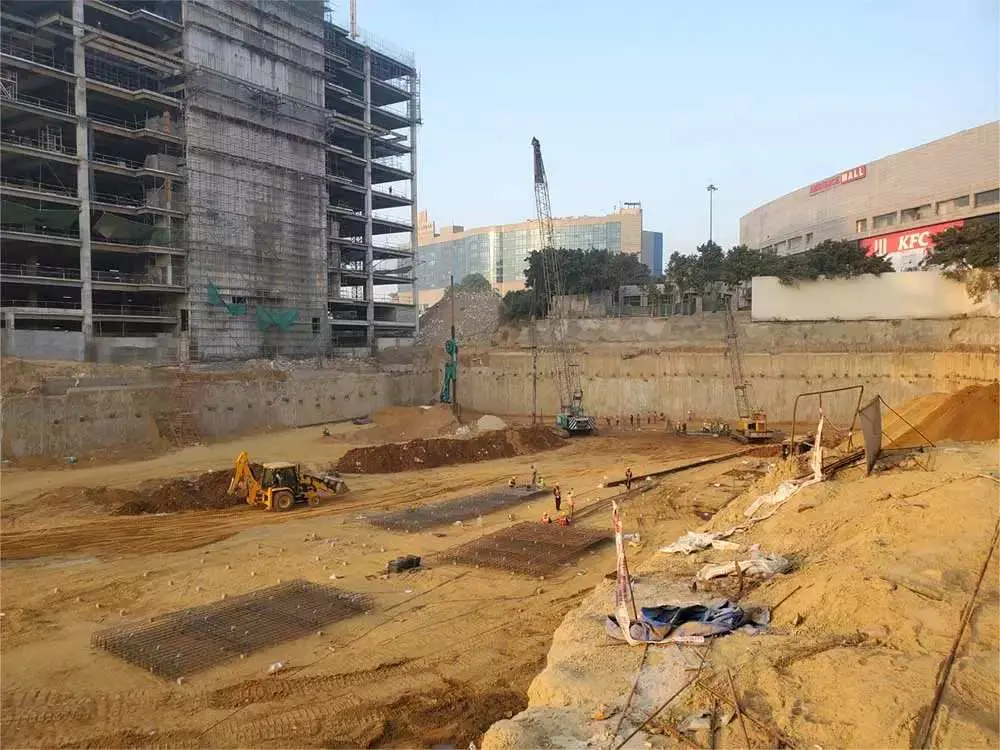 Kentsel derin kazı çukuru — ankrajlı fore kazık perde, zemin taşıyıcı katman, ekskavatör ve vinç saha ekipmanları