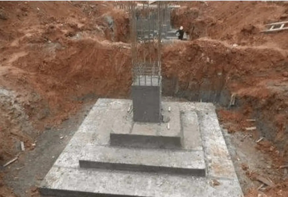 Tamamlanmış tekil temel — basamaklı kare pabuç temel betonu, üstünde kolon donatısı ve kalıbı görülüyor