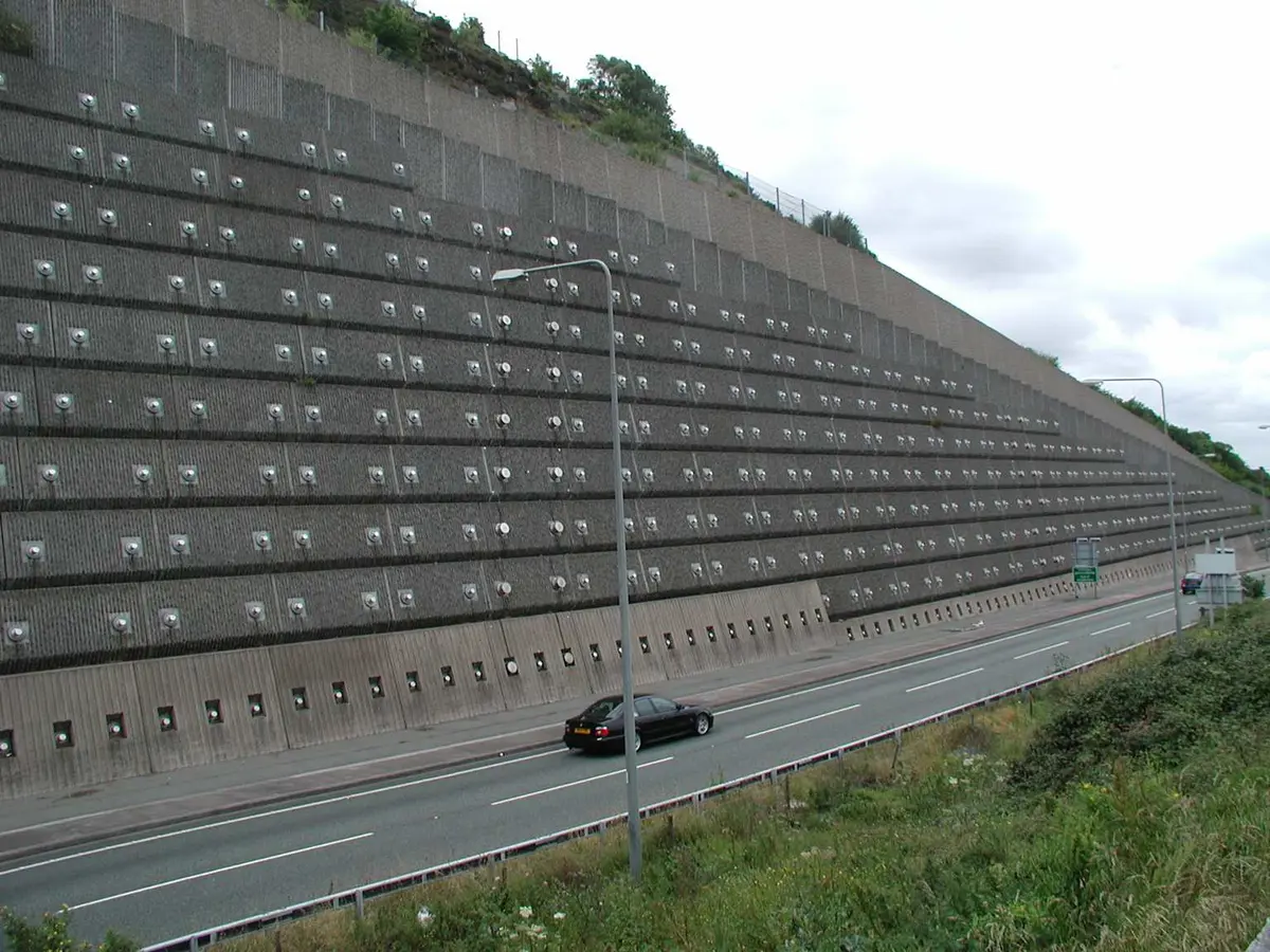 Büyük ankrajlı istinat duvarı — otoban kenarı yüksek beton istinat duvarı, ankraj başlıkları grid düzeninde