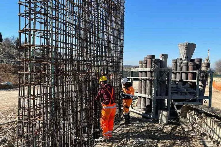 Diyafram duvar donatı kafesi montajı: dikey ana donatılar ve yatay etriyeler; arka planda tremie beton döküm ekipmanı