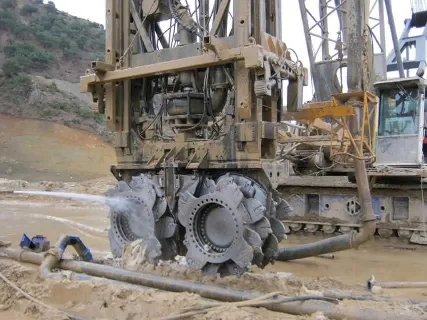 Hidrofrez (hydromill/cutter soil mixing) ekipmanı — çift frezel disk zemine girerken bentonit çamuru dispersiyon spreyi yapıyor